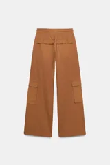 Pantalón cargo de tiro medio con efecto lavado, confeccionado en algodón. Presenta cintura elástica ajustable con cordones, bolsillos laterales y bolsillos de plastrón con solapa en las piernas. Diseño de pierna recta con combinación de tejidos a tono.