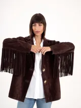 Blazer de gamuza color chocolate, con diseño de flecos largos en la parte posterior de las mangas y espalda. Presenta cierre frontal con botones y solapas clásicas.