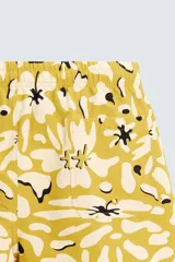 Bañador de hombre de tejido técnico ripstop, color mostaza con estampado floral abstracto en blanco y negro. Presenta cintura elástica ajustable con cordón, bolsillos laterales y bolsillo trasero de plastrón.