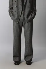 Pantalón de traje relaxed fit en color gris oscuro con diseño de espiga. Cuenta con bolsillos frontales, bolsillos traseros de vivo y cierre frontal con cremallera y botón.