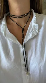 Gargantilla roja de múltiples vueltas con cuentas plateadas y dijes redondos.