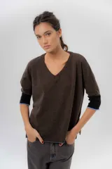 Buzo de punto confeccionado en lambswool, con diseño amplio, escote en V y mangas 3/4. Presenta una combinación de tonos rojos en la espalda con una franja central ancha y tajos laterales.
