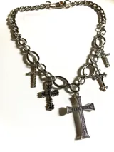 Collar plateado de cadena gruesa con dijes de cruces de diferentes estilos.