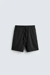 Bermuda de corte regular confeccionada en tejido fluido con textura jacquard geométrica. Cuenta con cintura elástica ajustable con cordón, bolsillos laterales y bolsillos traseros de vivo.