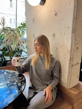 Sweater gris de tejido acanalado, corte suelto y tajos a los costados.