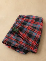 Pijama largo a cuadros de franela en tonos azul, rojo y verde, compuesto por una camisa de manga larga con solapas y botones frontales, y un pantalón largo de corte recto con puños y detalles en tartán verde.