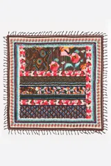 Chal de algodón con diseño estampado multicolor, bordes decorados con guardas y flecos anudados en los extremos.