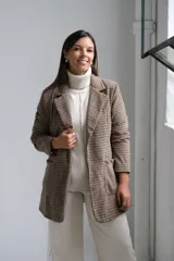 Blazer de corte recto con estampado de cuadros tipo príncipe de gales en tonos marrones y beige. Presenta solapas clásicas, bolsillos frontales aplicados y mangas largas.