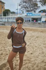 Musculosa de punto acanalado color marrón, con ribetes celestes en el cuello y las sisas, y un bordado de corazón en el pecho.