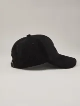 Gorra de béisbol de pana azul marino con parche lateral con el logo de la marca Benson & Thomas.