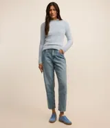 Suéter corto de punto liviano color blanco, con cuello alto y mangas largas.