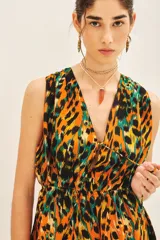 Vestido corto sin mangas con escote en V y elástico fruncido en la cintura. Presenta un estampado animal print vibrante en tonos naranja, negro y verde esmeralda.
