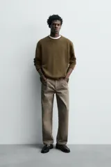 Jersey de punto de lana con corte regular fit, cuello redondo y manga larga. Presenta un diseño minimalista con acabados enrollados en cuello, puños y ruedo.