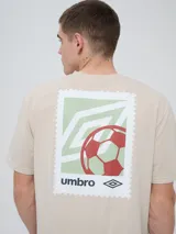 Remera de manga corta color beige, con cuello redondo y diseño holgado. Cuenta con un pequeño estampado rectangular en el pecho con motivo futbolero.