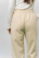 Pantalón deportivo de corte wide leg con caída relajada. Presenta cintura elastizada con cordón ajustable, bolsillos laterales y un interior frizado para mayor abrigo.