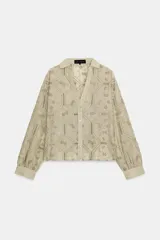 Camisa de cuello solapa con escote en V, manga larga y cierre frontal con botones. Presenta un diseño con bordados perforados en todo la prenda.