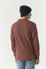 Polo de manga larga color beige con textura, fit regular, logo estampado y puños.