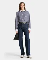 Camisa celeste claro a rayas verticales con cuello y puños blancos, corte oversized y bolsillo en el pecho con logo bordado.