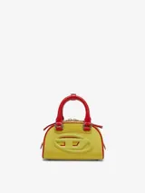 Bolso tipo mini bandolera con forma de domo, color amarillo vibrante con ribetes y asas superiores en rojo. Presenta el logo ovalado 'D' de Diesel en relieve en el frente.