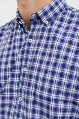 Camisa de manga corta con estampado a cuadros en tonos azul oscuro y celeste. Tiene cuello abotonado y corte clásico.