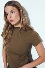Top de manga corta color verde oliva, con cuello alto y calce ajustado al cuerpo.