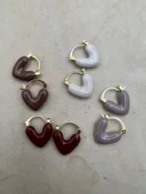Set de aros tipo argolla con forma de corazón esmaltados en diferentes colores: marrón, blanco, lila y bordó. El cierre es de tipo clip.