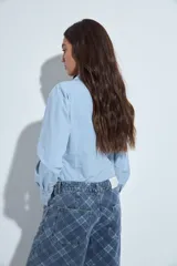 Jean de corte wide leg con estampado de cuadros en tonos azules. Presenta un diseño de tiro medio y silueta amplia, confeccionado en denim estructurado.