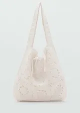 Bolso tipo shopper confeccionado en tejido de crochet de algodón, con diseño de motivos circulares, asa de hombro y cierre mediante lazo.