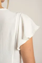 Blusa negra de manga corta con volados en los hombros, escote en V y cierre frontal con botones pequeños.