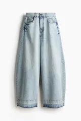 Jean de cinco bolsillos en denim de algodón rígido, corte holgado con cierre y botón. Cuenta con piernas amplias de diseño curvado, raya marcada y bajo deshilachado.