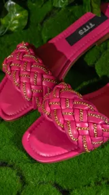 Sandalias negras con tiras trenzadas y cadena dorada.