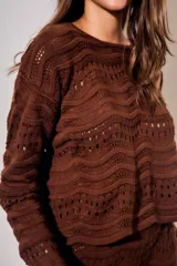 Sweater oversize de tejido de punto color blanco con diseño calado de ondas y cuello redondo, de manga larga.
