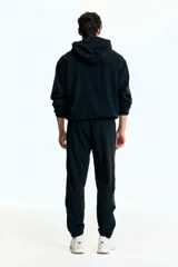 Jogging deportivo negro de corte estándar, confeccionado en punto funcional con tecnología DryMove™ que absorbe el sudor. Presenta cintura elástica con cordón de ajuste, bolsillos al bies con cierre y bajos ajustados con cierre y elástico.