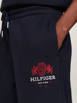 Pantalón de jogging azul marino, de corte cónico, con cintura elástica ajustable con cordón, bolsillos laterales y logo bordado en rojo.