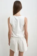 Musculosa blanca de algodón, de corte recto y escote redondo.