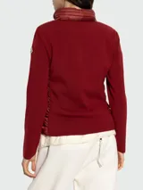 Cardigan híbrido de Moncler con frente acolchado tipo puffer en color bordó y mangas de punto de lana virgen al tono. Presenta cierre frontal completo y cuello alto.