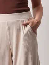 Pantalón capri plisado color beige, marca Dictionary, con pretina ancha elastizada y bolsillos delanteros.