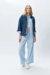 Pantalón largo de tela rayada celeste y blanco, con cintura elástica.