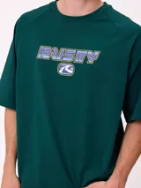 Remera de corte holgado color gris melange, con mangas raglán y estampado frontal con el logo de la marca Rusty en tonos azul y rojo.