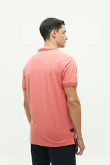 Polo de piqué color salmón, de corte regular, manga corta y logo estampado en el pecho. Confeccionada en algodón y spandex.