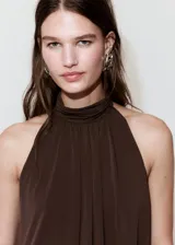 Vestido corto marrón con cuello halter y detalle drapeado en el torso, falda ajustada con fruncidos y diseño sin mangas.