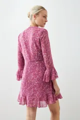 Vestido corto fucsia con estampado floral, escote en V, mangas largas con volados y falda acampanada con volados en el ruedo.