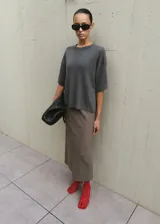 Chaleco de punto gris oscuro con escote redondo y mangas cortas holgadas.