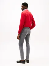 Pantalón jean slim gris con efecto desteñido y usado en la cintura. Confeccionado en tejido denim elástico de algodón. Cierre de cremallera con botón y diseño de cinco bolsillos. Incluye logo de Tommy Hilfiger bordado en el bolsillo trasero.