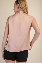 Top sin mangas de satén color rosa pálido, con cuello tipo cowl drapeado y corte recto.