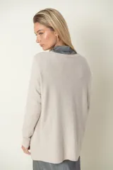 Buzo verde oliva de punto fino con detalle de líneas diagonales en el mismo material y cuello camisero blanco.