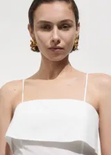 Vestido midi de algodón color blanco con escote cuadrado y detalle de solapa vuelta. Presenta tirantes finos y diseño evasé.