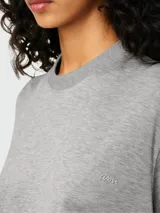Remera de algodón gris con cuello redondo y logo bordado pequeño en el pecho.