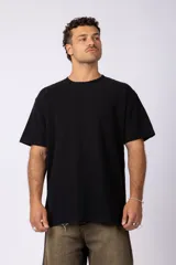Remera de corte oversize color negro, con cuello redondo y detalle de costura en forma de X en el frente.