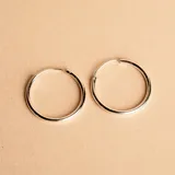 Aros tipo argolla de diseño minimalista, fabricados en plata 925 con acabado pulido.